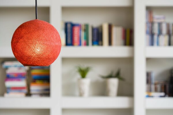 Red lamp on a background of white shelves