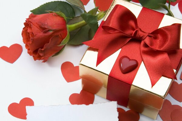 A gift with a red bow, a rose and hearts