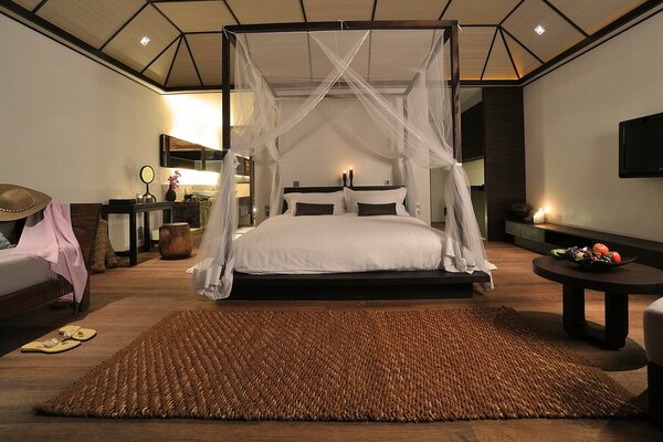 A huge four-poster bed in the middle of a hotel room