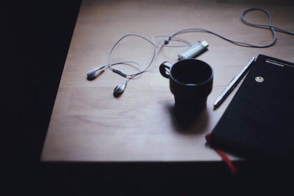 En la mesa del planificador diario taza y auriculares