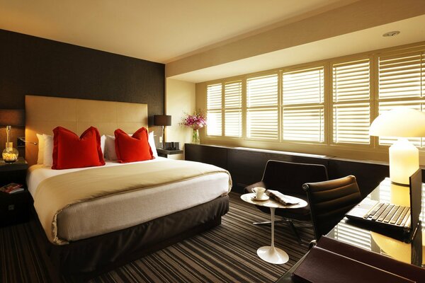 The interior of a room in a hotel with a chic bed and flowers