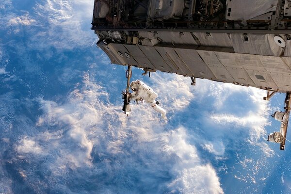 Astronauta w kosmosie przy stacji kosmicznej