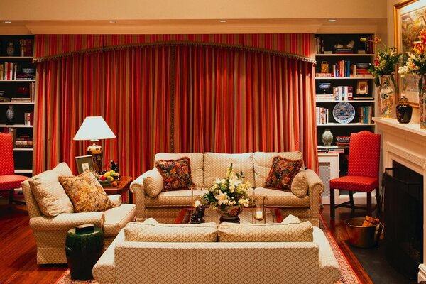 Red living room with beige sofas, bouquet on the table