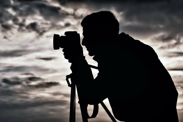 A man is preparing to take pictures with a tripod