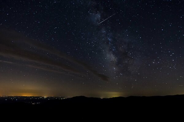 Les lumières lointaines de la ville, le ciel dans les étoiles, la voie lactée