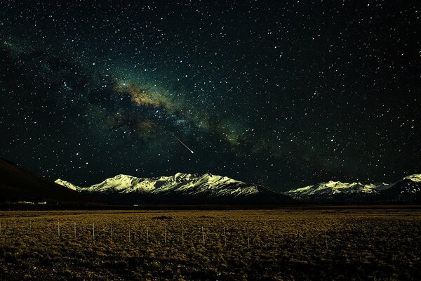 Campo puro montañas nevadas y la vía láctea