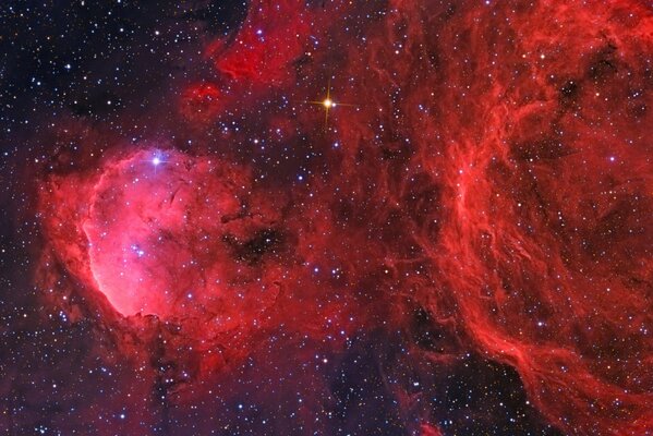 Nebulosa scarlatta con bagliore blu e giallo sullo sfondo del cosmo stellato nero