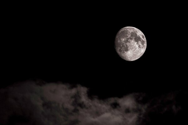 Mond auf schwarzem Hintergrund und schwebende Wolken