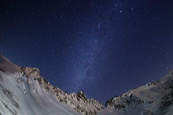 Voie lactée dans les montagnes enneigées