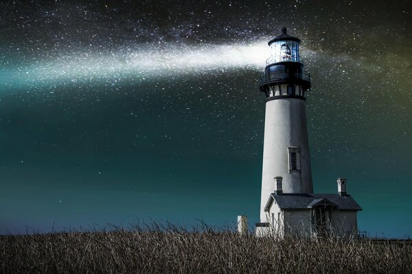 Le phare dans le champ passe par les rayons du ciel du soir