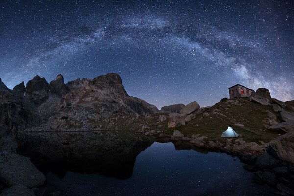 Hermoso reflejo de la vía láctea en el lago en el fondo de las montañas