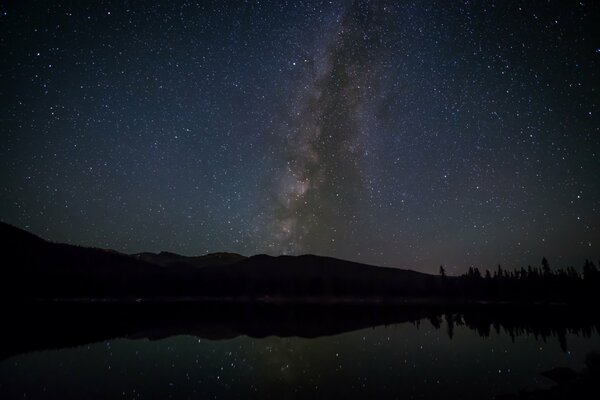 La Via Lattea e le stelle, e sotto il lago e la foresta