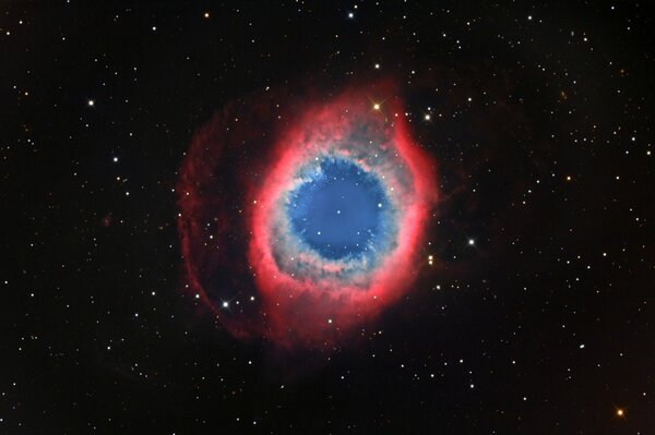 Red snail nebula with blue and green in outline on black starry space