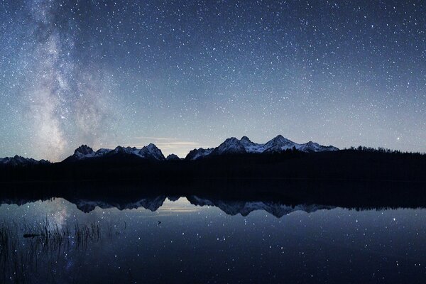 Ein Bergsee, in dem sich der Sternenhimmel widerspiegelt