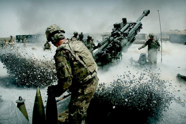 Artillery crew at work recoil from the volley in the winter landscape