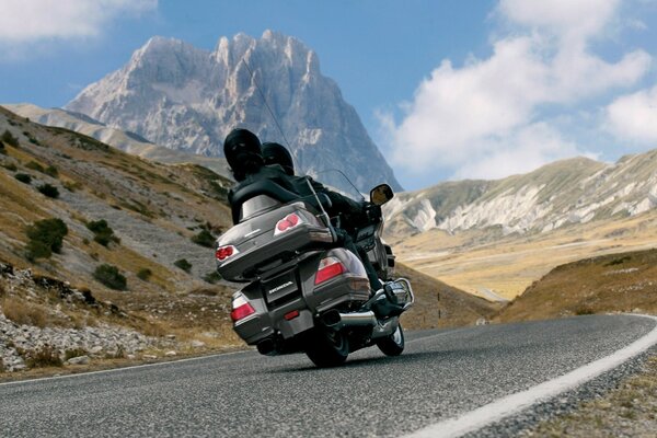 Silver motorcycle on the road to the mountains