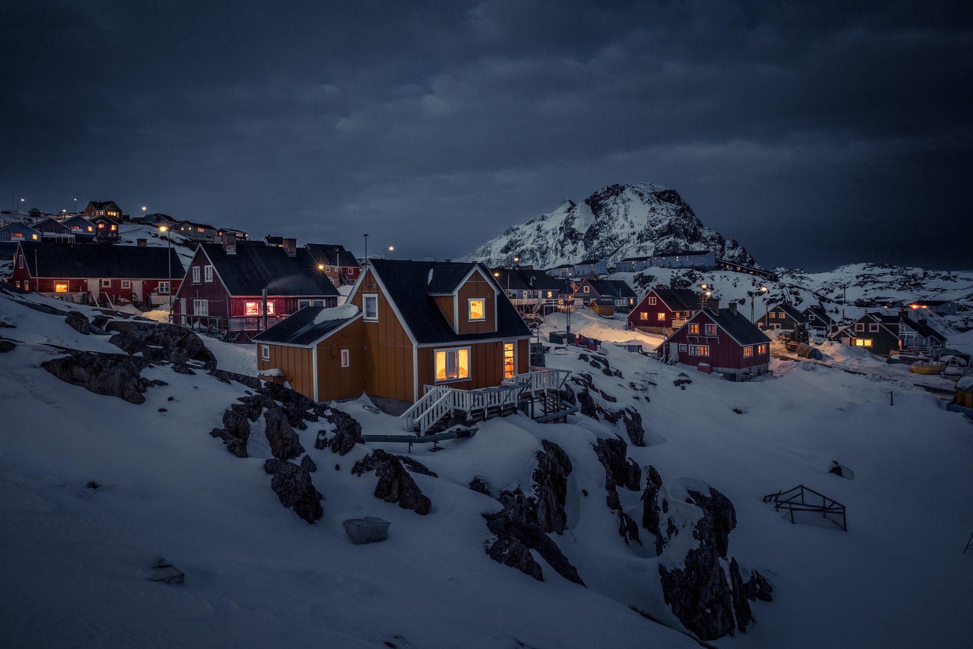 groenlandia sisimiut case luci neve notte montagne nuvole grigie tempesta