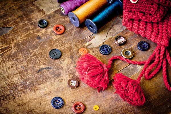 Boutons multicolores et bobines de fil sur le vieux sol