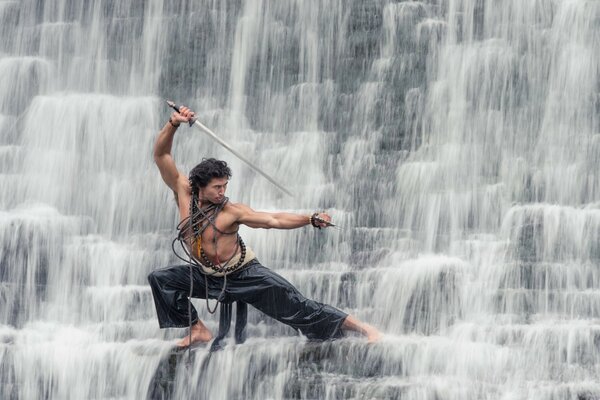 Un hombre con una espada en una cascada