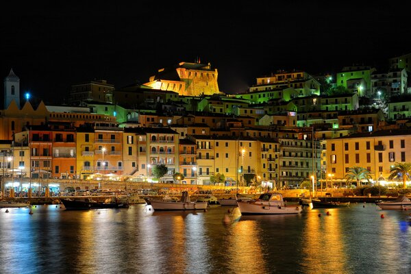 Una ciudad italiana nocturna a orillas del puerto