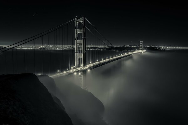 Nocny most Bay Bridge we mgle. Światła nocnego miasta