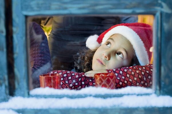 Brown-eyed girl at the window. Waiting for a miracle