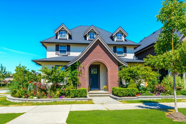 A mansion with a beautiful lawn and a garden