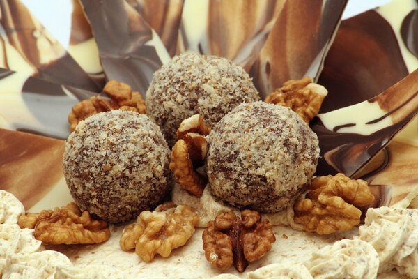 A cake sprinkled with walnuts and chocolate on top