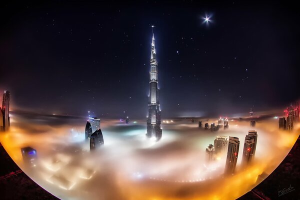 Wieża Burj Khalifa jest spowita chmurami. Gwiaździste niebo nad Dubaj