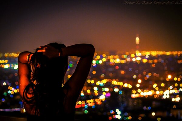 A girl against the background of the night lights of Tehran