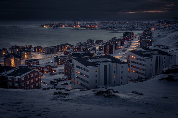 Ville du soir enneigée au bord de la baie