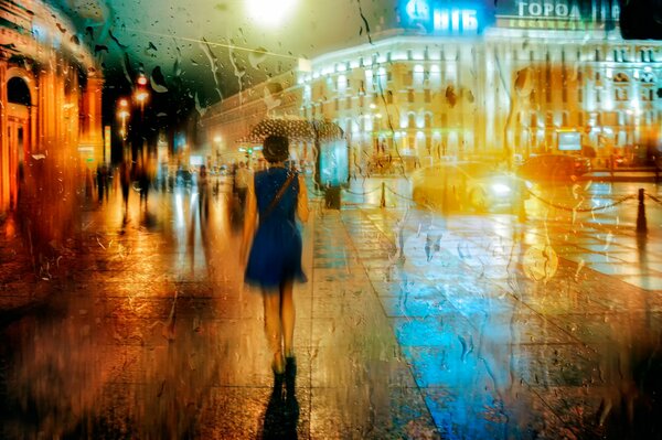 A girl walks down a rainy street