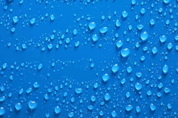 Muchas gotas de agua sobre un fondo azul