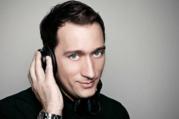 A man with headphones on a gray background