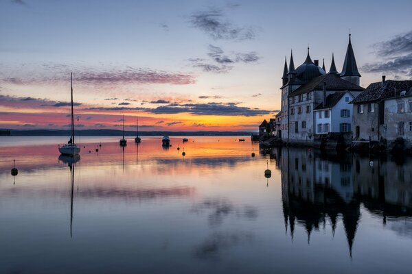 Castello sul lago la sera. Riflesso del tramonto nel lago
