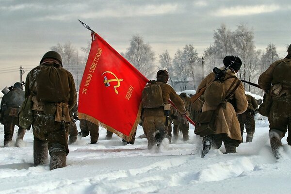 Soldiers carry a banner across the field