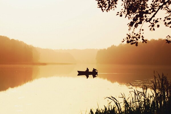 Barco en el lago en la bruma de la mañana