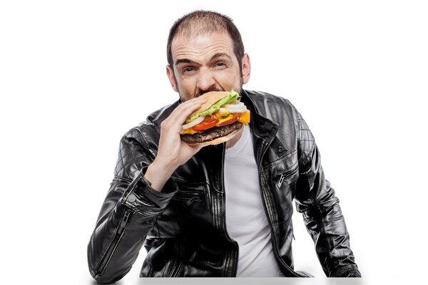 Ein Mann in Leder isst einen Hamburger