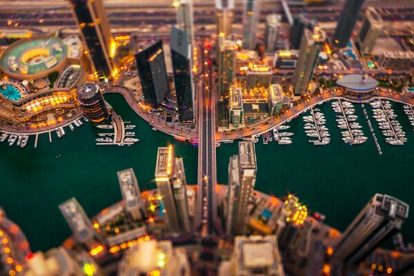 Vista dall alto della Notte di Dubai. Le barche sono visibili, le luci sono accese intorno