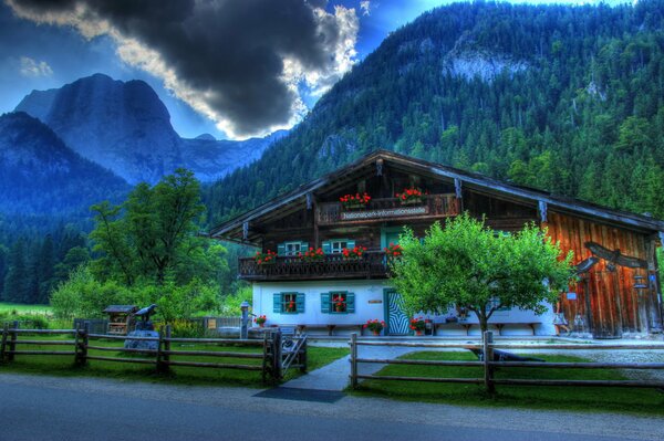 Германия hdr. Дом позади которого горы. Фото со стороны забора
