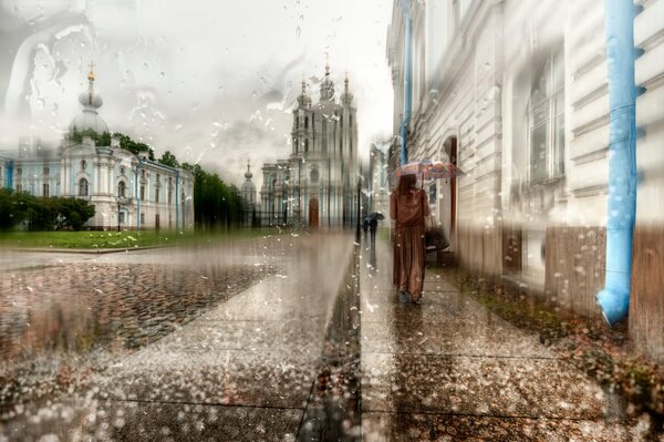 Mädchen in einem langen Mantel unter einem Regenschirm in St. Petersburg