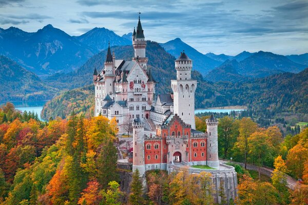 Castello di Neuschwanstein sullo sfondo della foresta e delle montagne autunnali