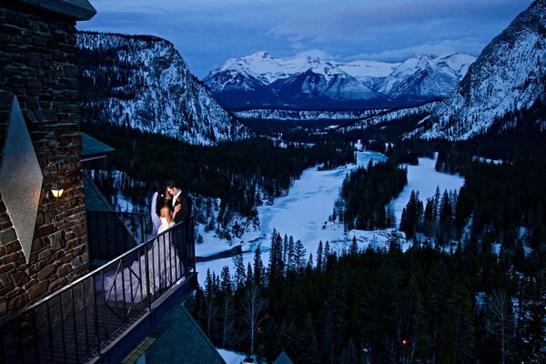 Hochzeitspaar auf dem Balkon vor dem Hintergrund der Berge