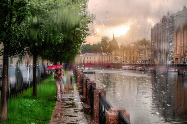 Una niña caminando bajo la lluvia en San Petersburgo