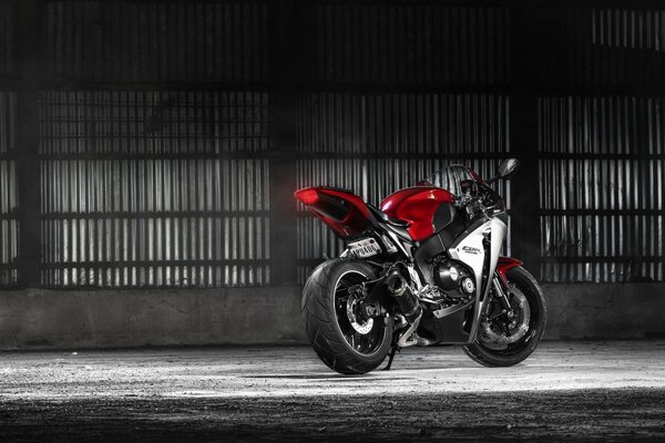 Motorcycle with red elements on the background of a silver fence