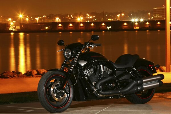 Czarny Motocykl Harley Davidson na tle wieczornego miasta