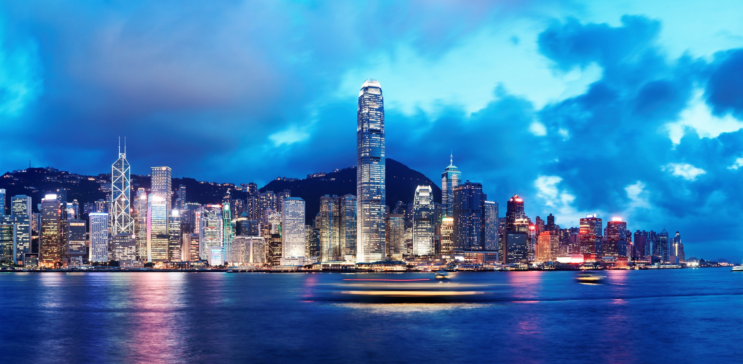 hong kong china city skyline lights sea river night ships buildings sky clouds nature town horizon