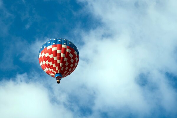 Globo de aire caliente contra el cielo azul y las nubes