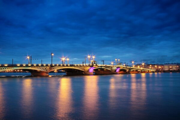 Puente luminoso sobre el río nocturno