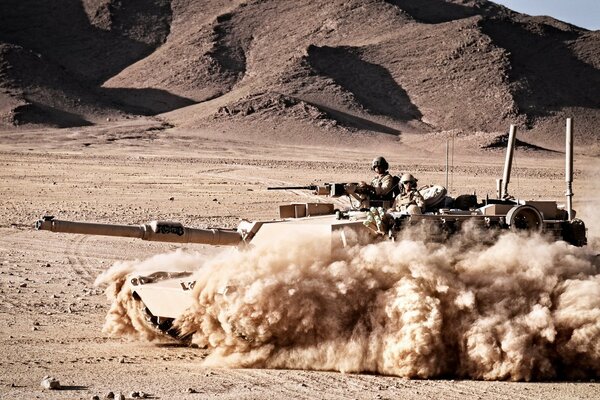 Soldiers riding on a tank with weapons